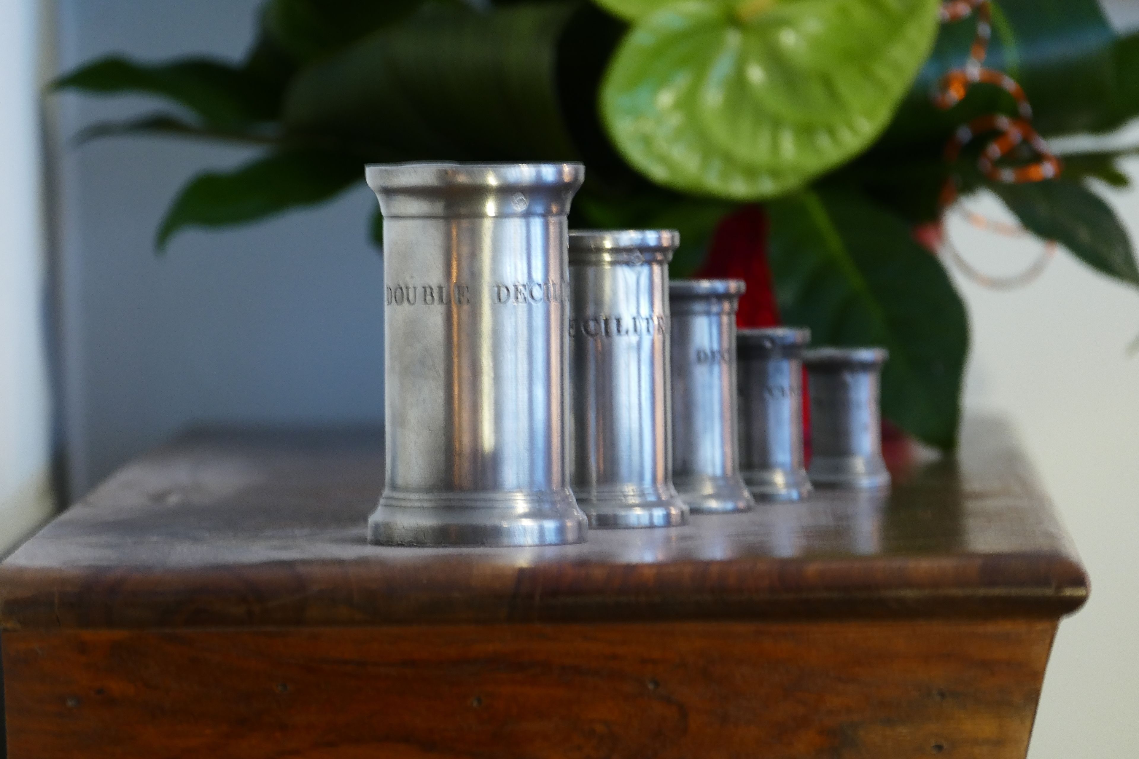 Una mesa de madera con cuatro recipientes metálicos etiquetados como 'Mobile Deco' y 'Eclectic'.