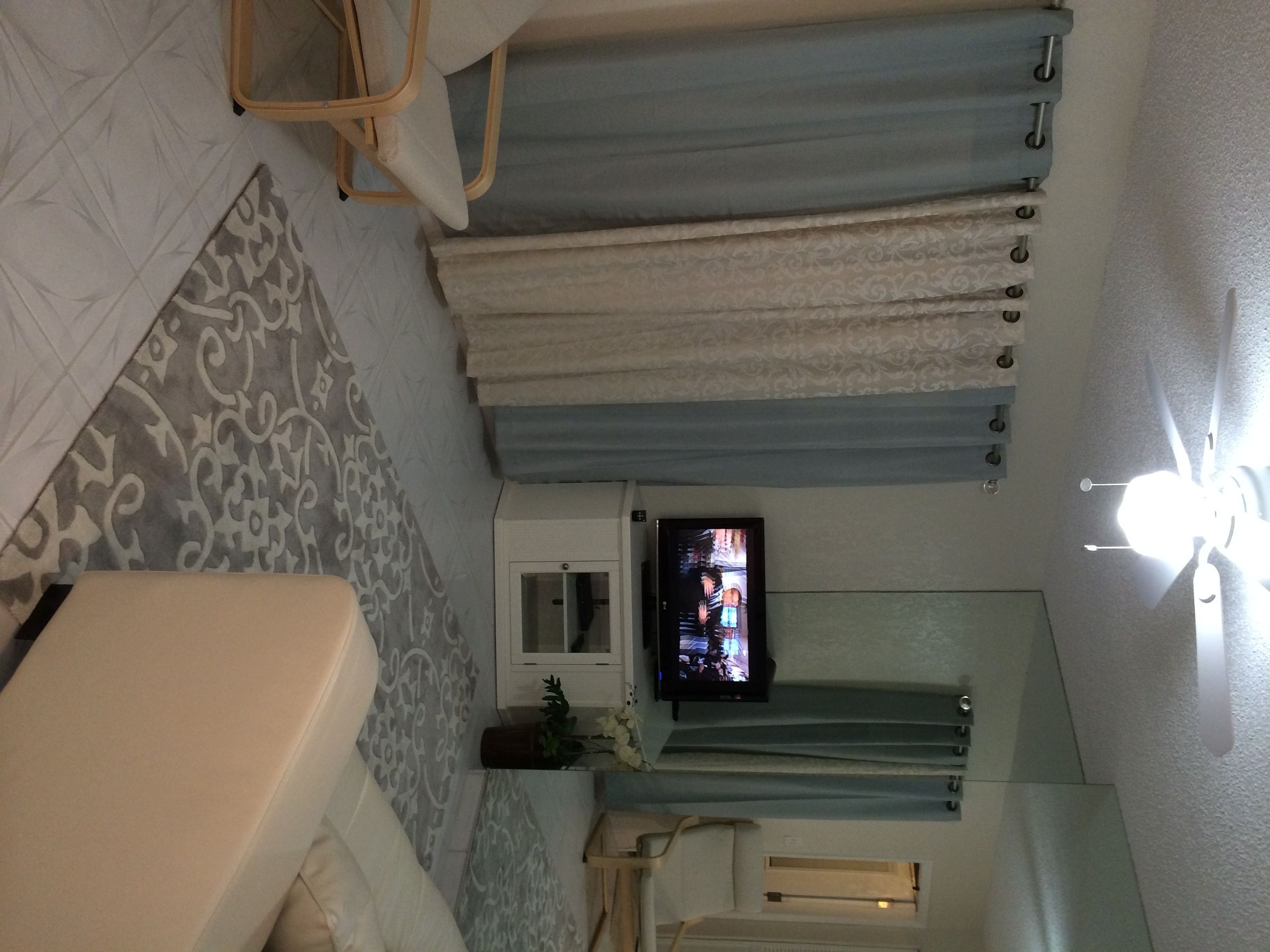Un bagno con una vasca, uno specchio, una televisione e una ventola a soffitto.