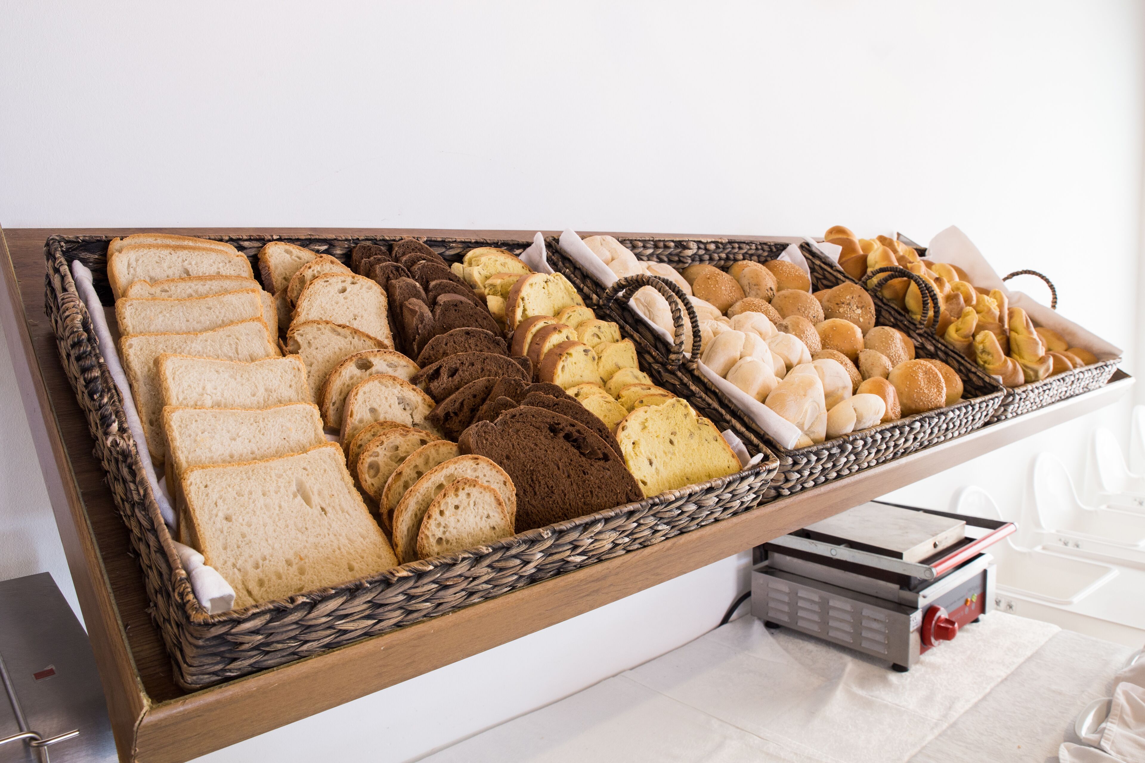 A variety of breads and pastries displayed in a wooden basket.