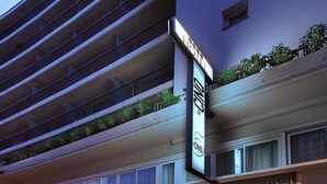 Un hotel con una fachada moderna, varios balcones y un llamativo letrero que dice 'CINO HOTEL'.