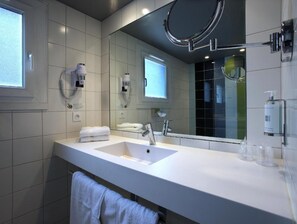 A modern bathroom with a large mirror, two sinks, and a towel rack. - Hôtel Le Cinq Hyper Centre Ville (Chambery)