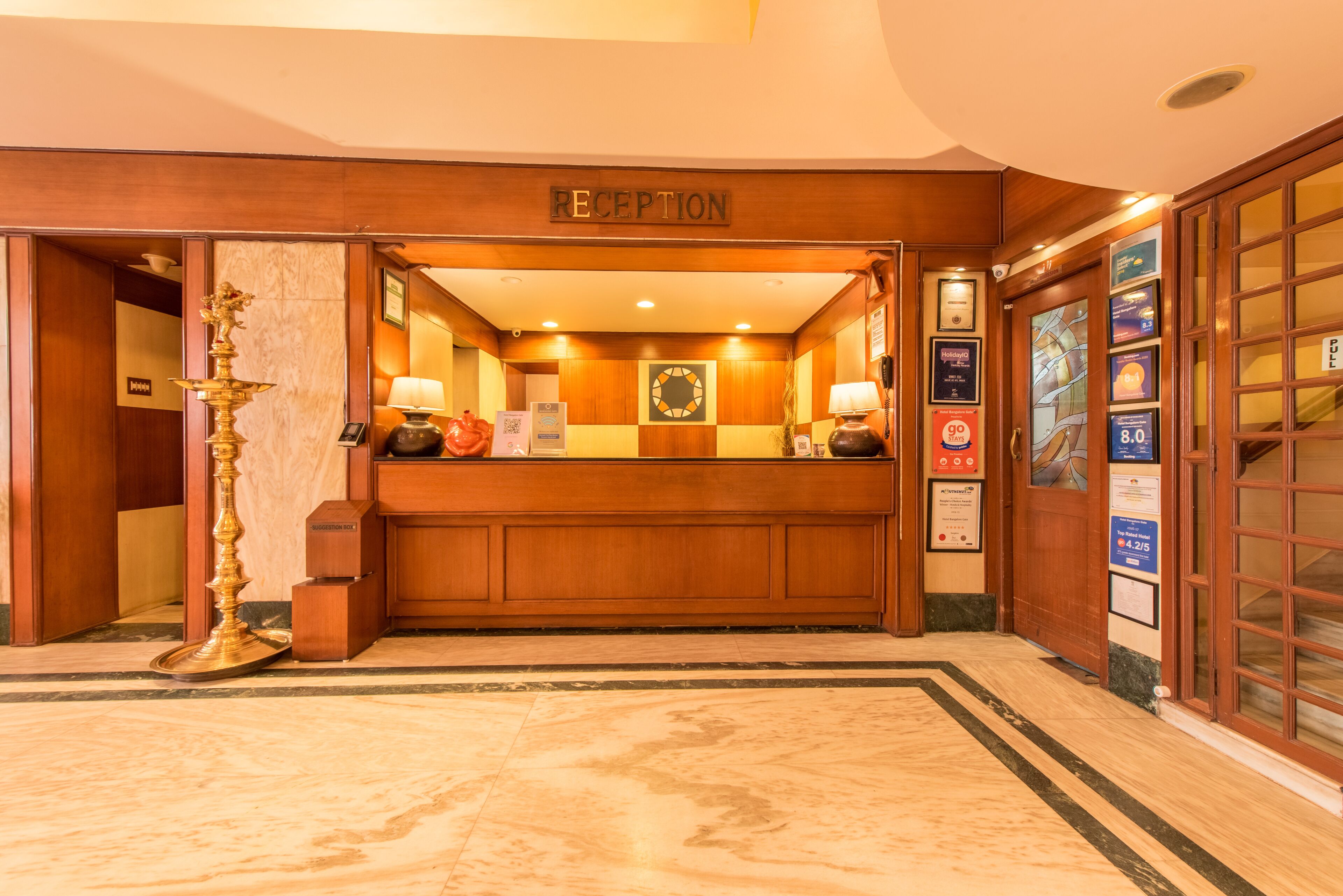 A reception area with a wooden reception desk, a wall-mounted clock, and a sign indicating the reception.