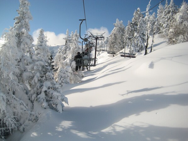 A ski lift with snow-covered trees and a clear sky. - Hotel Sporting Ravelli (Mezzana)