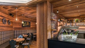 Ein gemütliches Holzinterieur mit Barbereich, Sitzgelegenheiten und einer Auswahl an Flaschen.