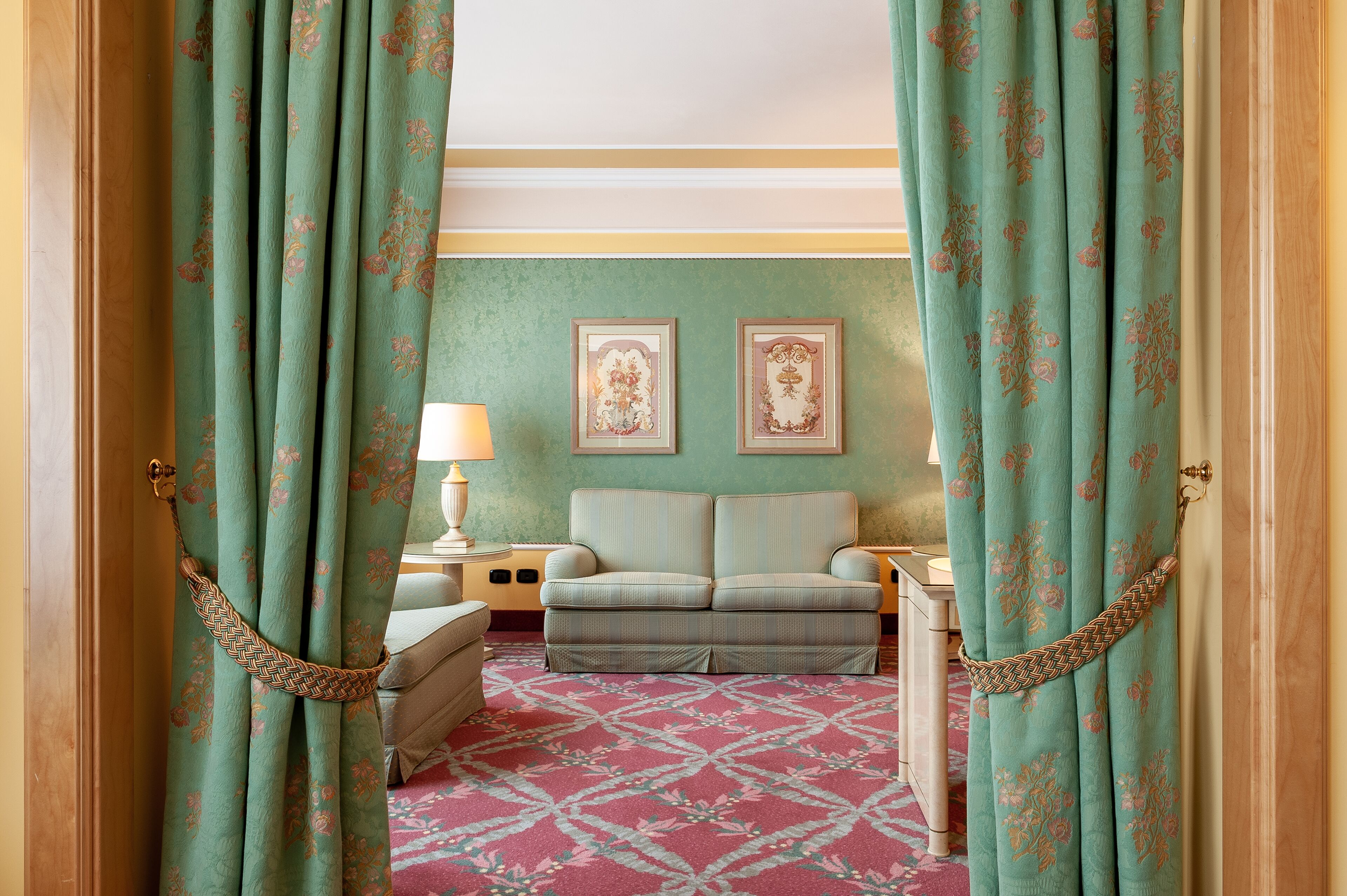 Une pièce avec un canapé, deux tableaux encadrés au mur et un tapis à motifs.