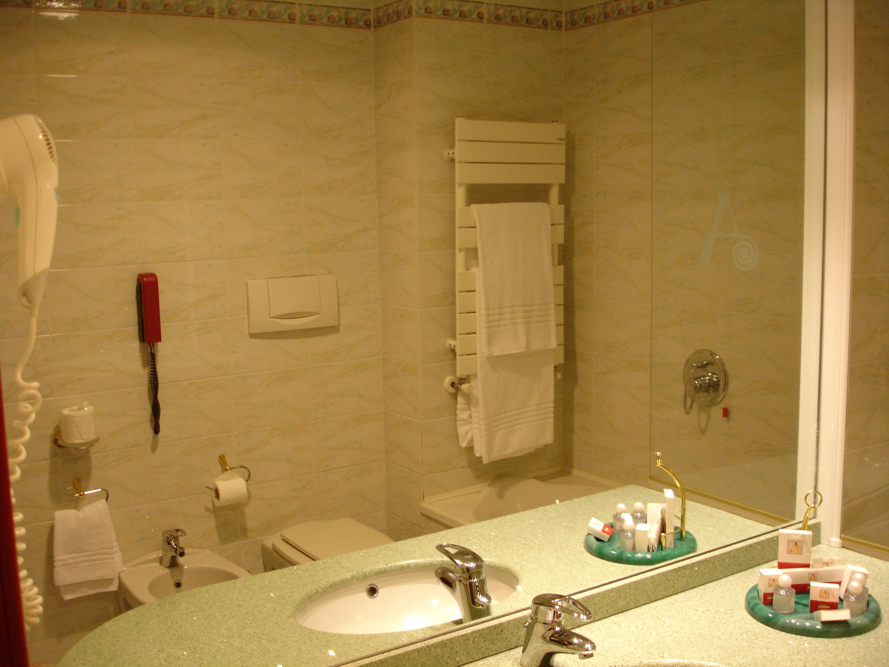 A bathroom with a sink, mirror, and towel rack.