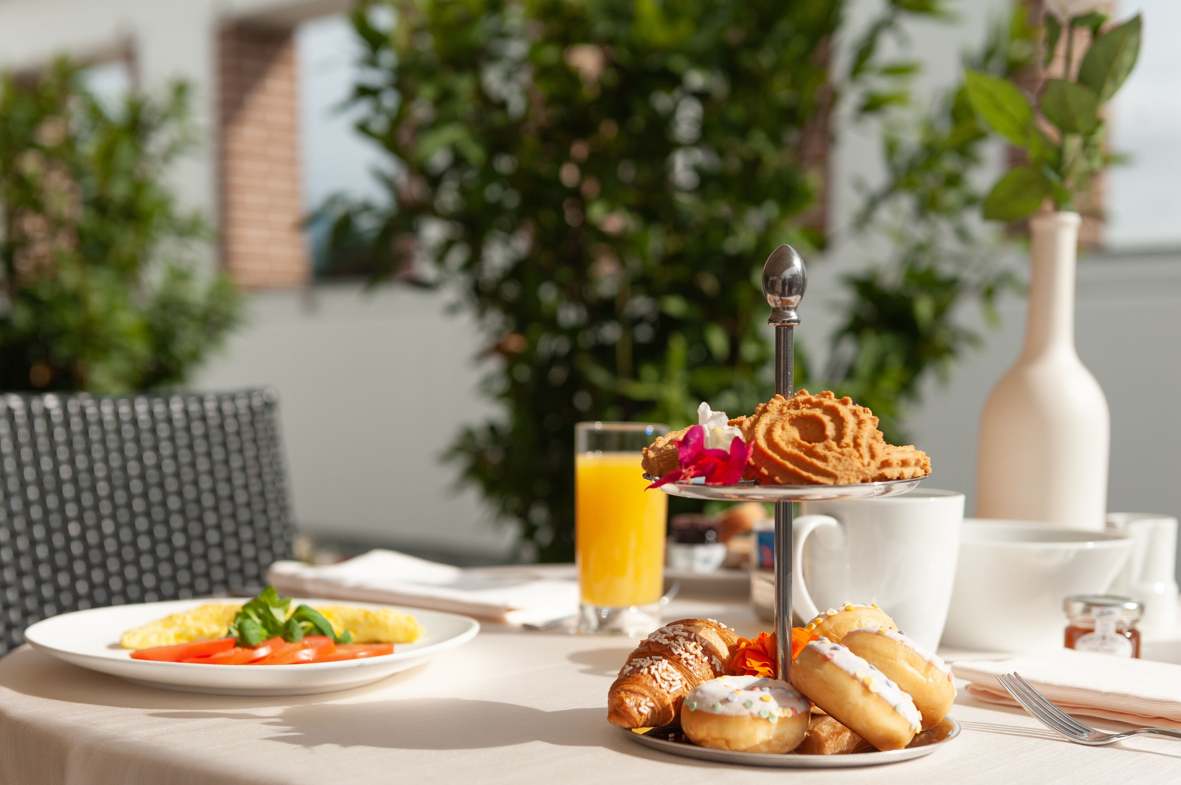 Ein Frühstückstisch mit Croissants, Gebäck und einem Glas Orangensaft.