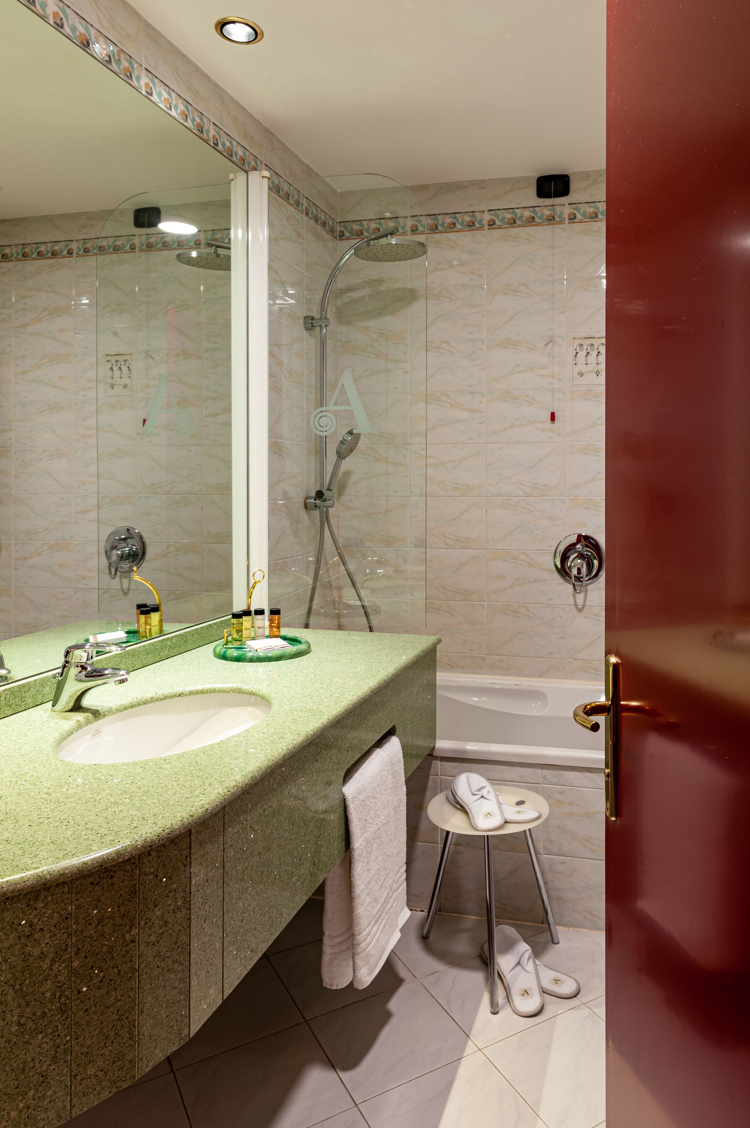 Une salle de bain avec un plan de toilette vert, un lavabo, un miroir, une douche et une baignoire.