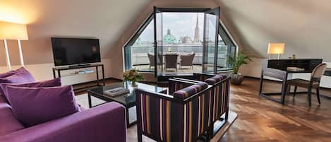 Un salon moderne comprenant un canapé, un téléviseur, un coin repas et une vue sur le paysage urbain.