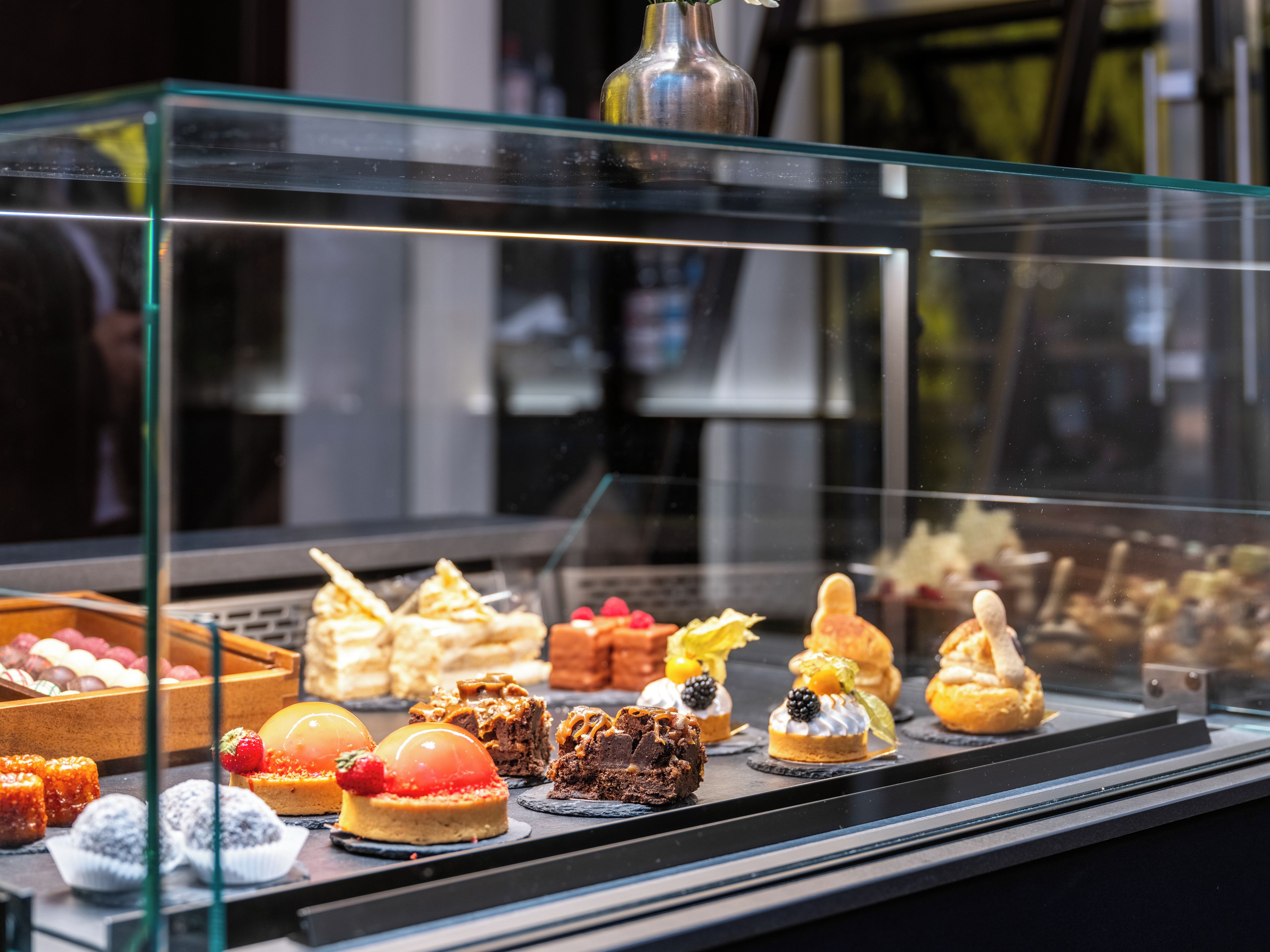 A variety of desserts displayed in a glass case.