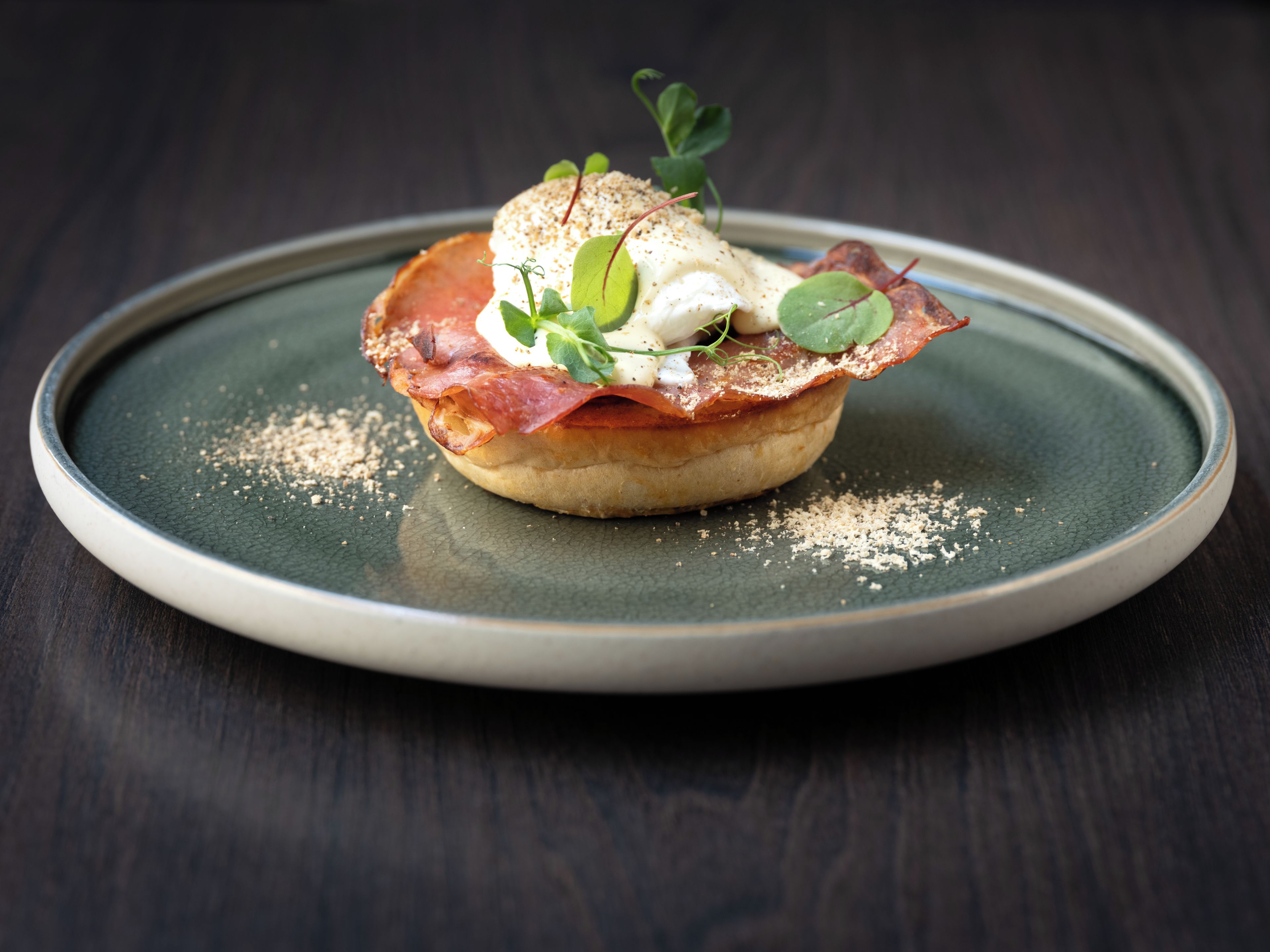 A round plate with a food item on a dark wooden table.