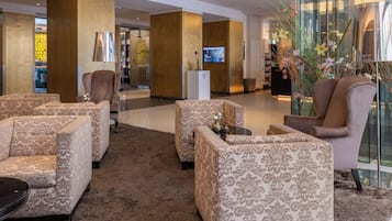Un hall con sofás, una recepción y una televisión.