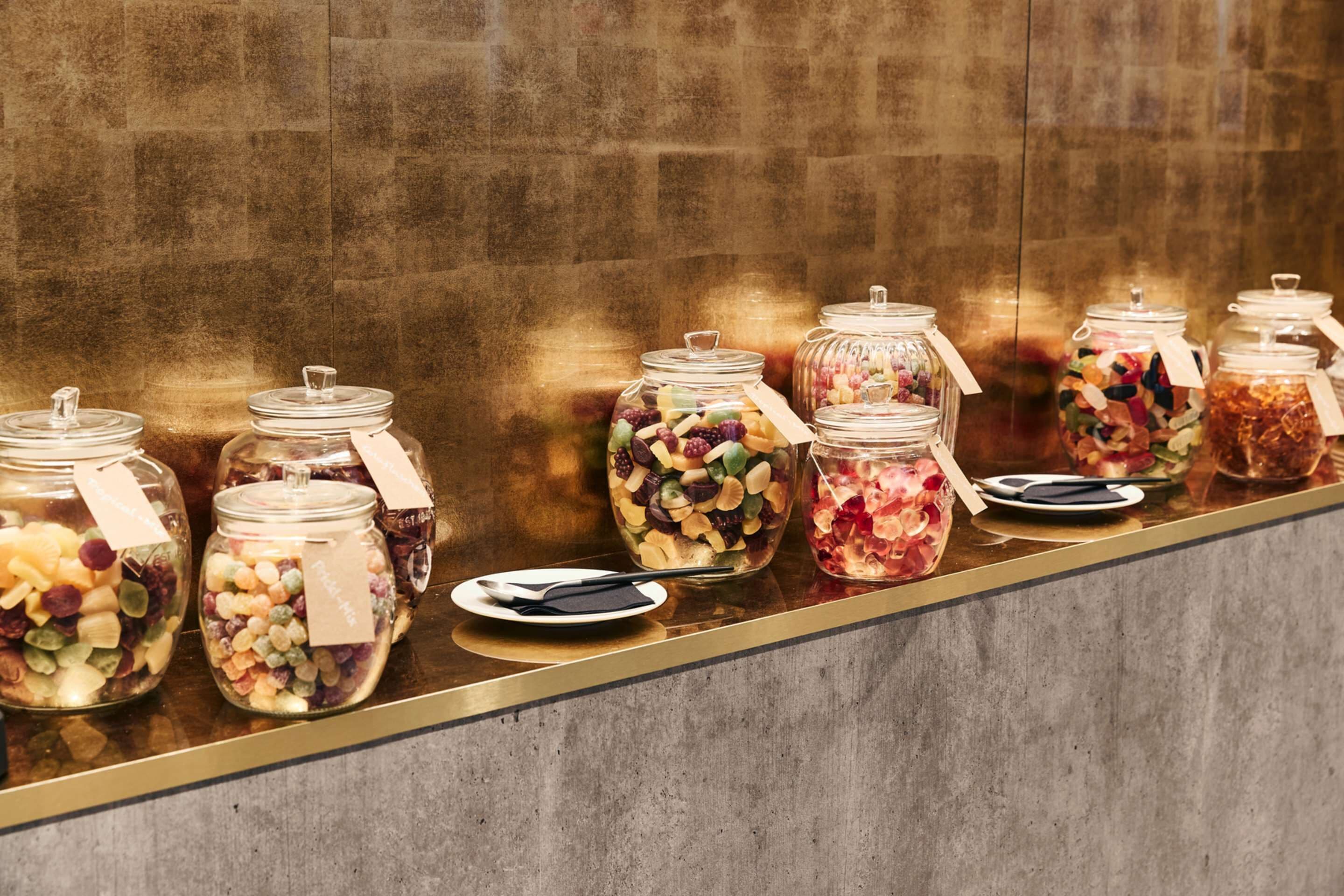 Una exhibición de frascos con diversos bocadillos y frutas.