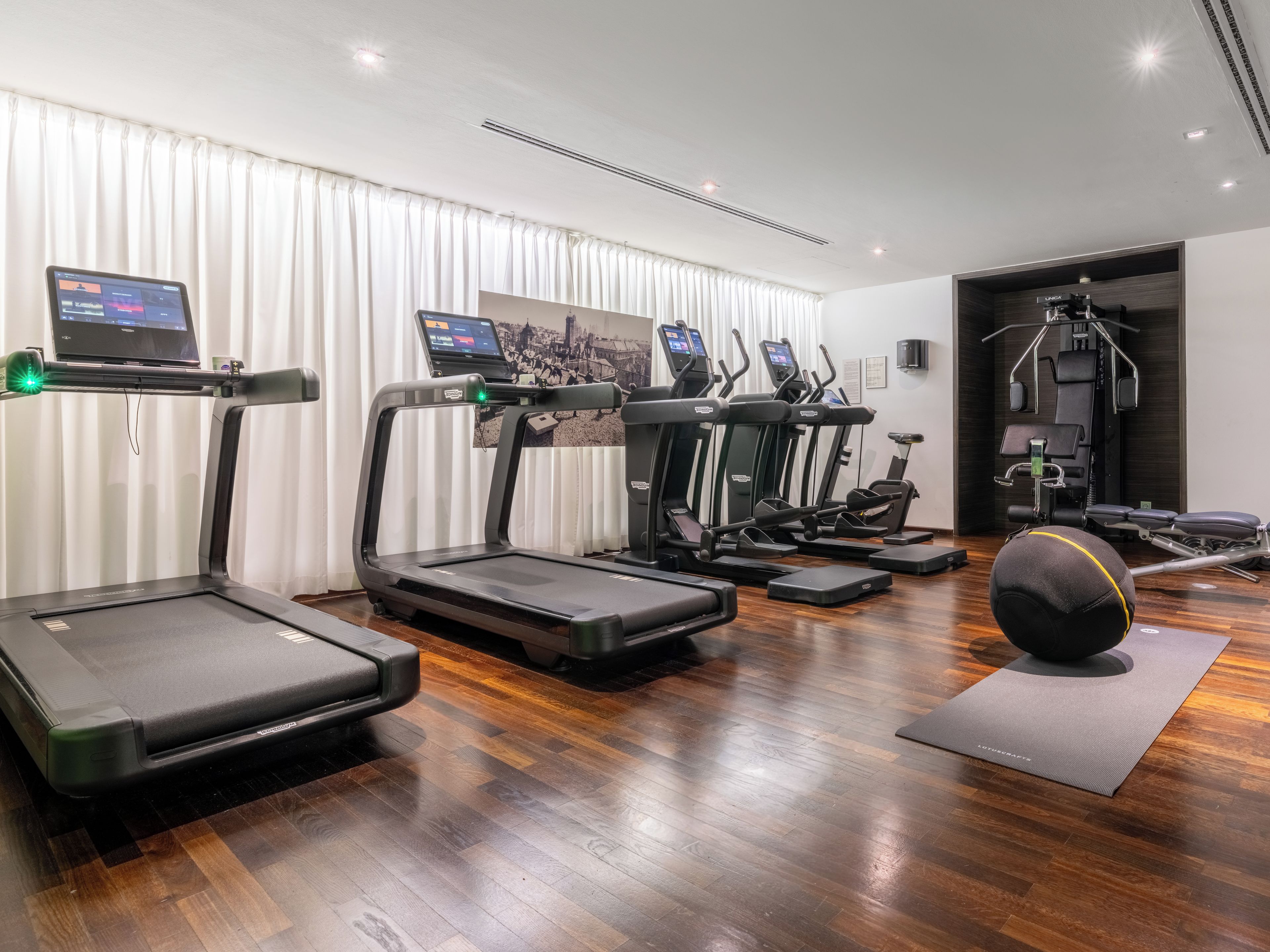 A gym with treadmills, elliptical machines, and a stationary bike.