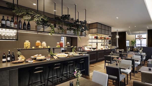 Un restaurante moderno con barra, asientos y una amplia variedad de comida y bebidas.