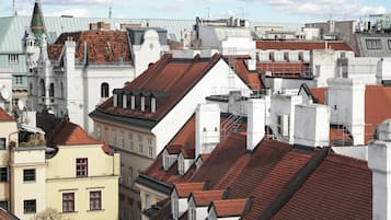 A cityscape with a variety of building rooftops, including some with dormer windows and chimneys.