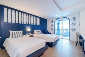 Una habitación de hotel moderna con dos camas, un ventanal grande y un balcón.