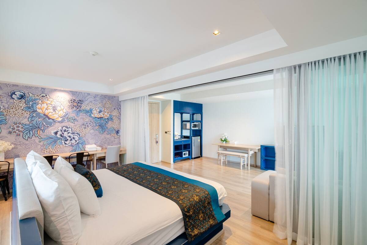Ett modernt hotellrum med en stor säng, ett skrivbord och en matplats.
