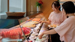 Een buffet met verschillende soorten eten en een persoon die serveert.