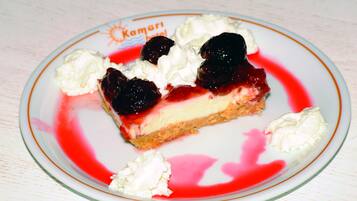 A slice of cheesecake with cherries and whipped cream on a plate.