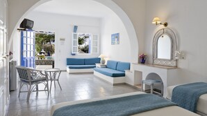 Quarto com um sofá azul, uma mesinha, uma cadeira e uma cama.