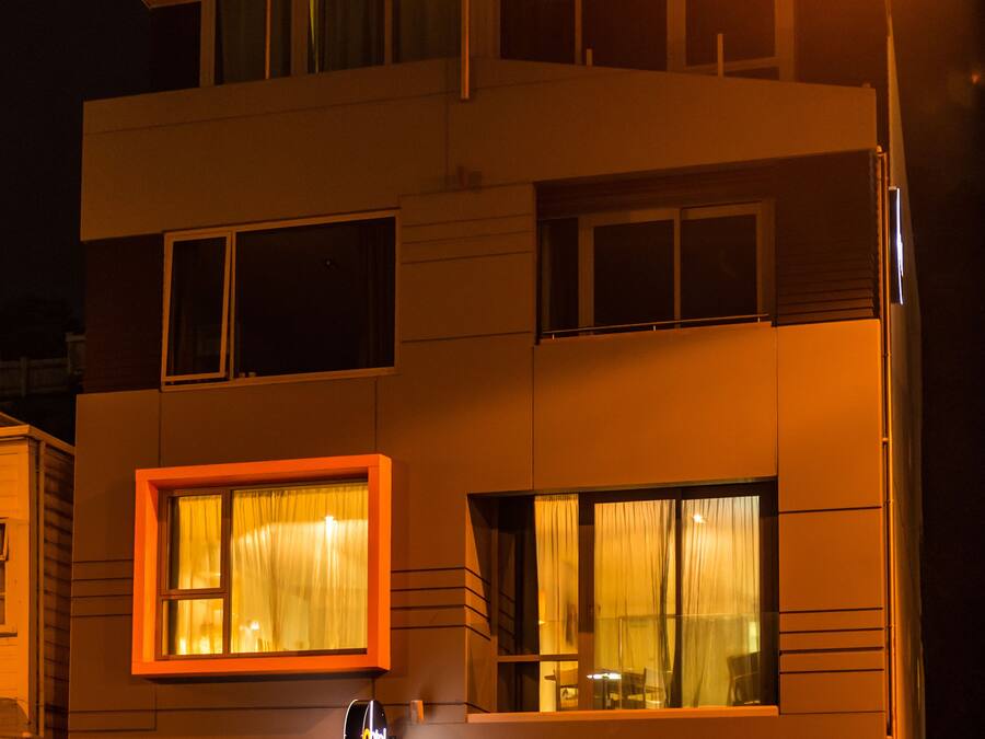 A modern hotel with a flat roof, large windows, and a sign reading "DUPPA BAR".