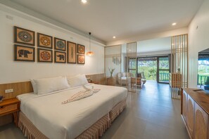 A spacious bedroom with a large bed, a wooden headboard, and a view of the outdoors through a sliding door.