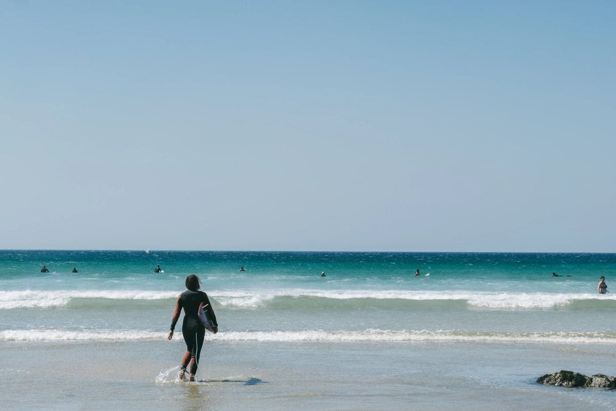 Ein Strand mit Wellen und Menschen im Wasser.