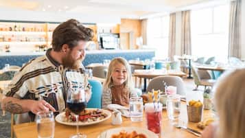 Un comedor con mesas, sillas y un bar al fondo.