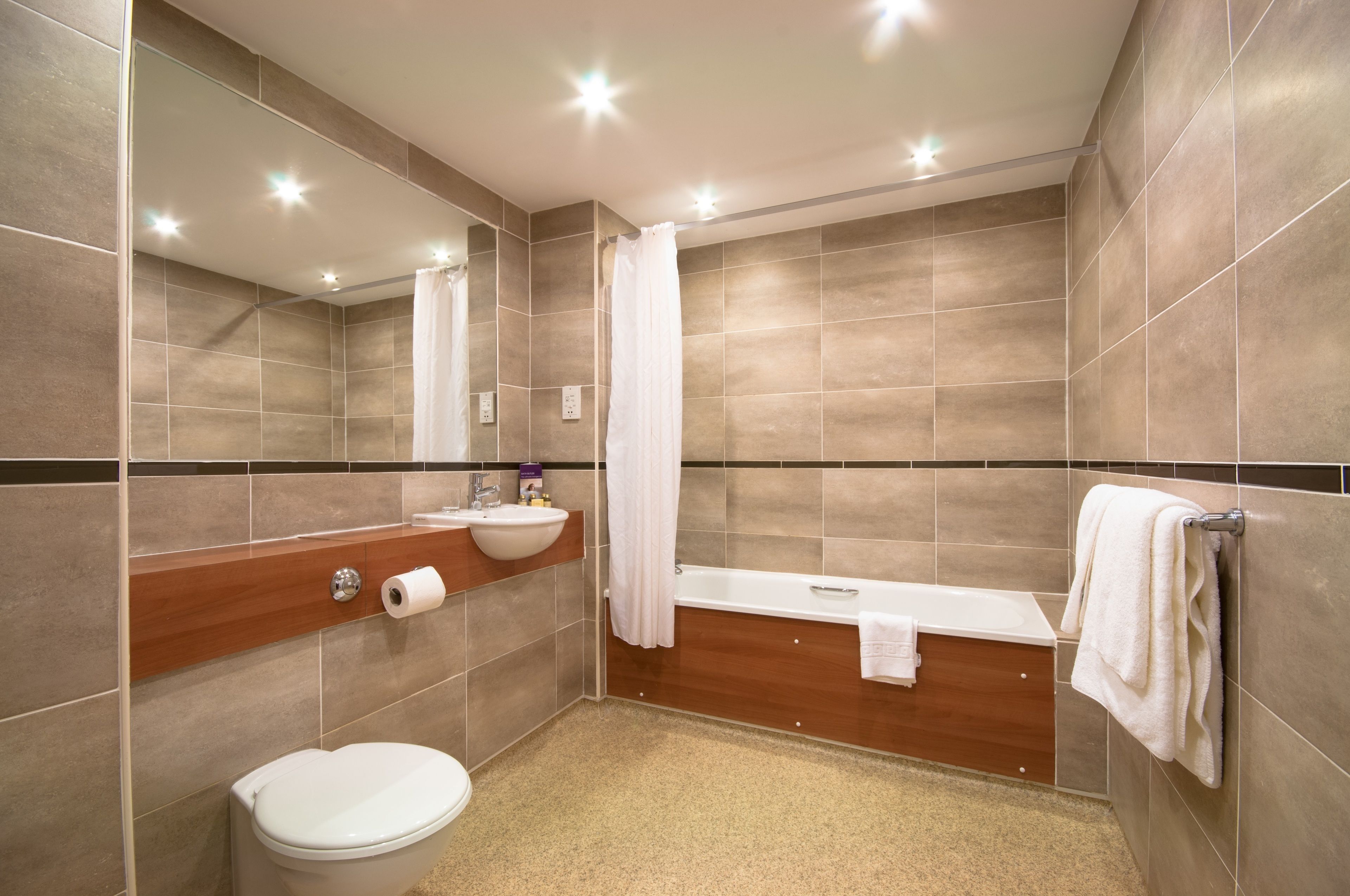 A modern bathroom with a toilet, sink, and bathtub.