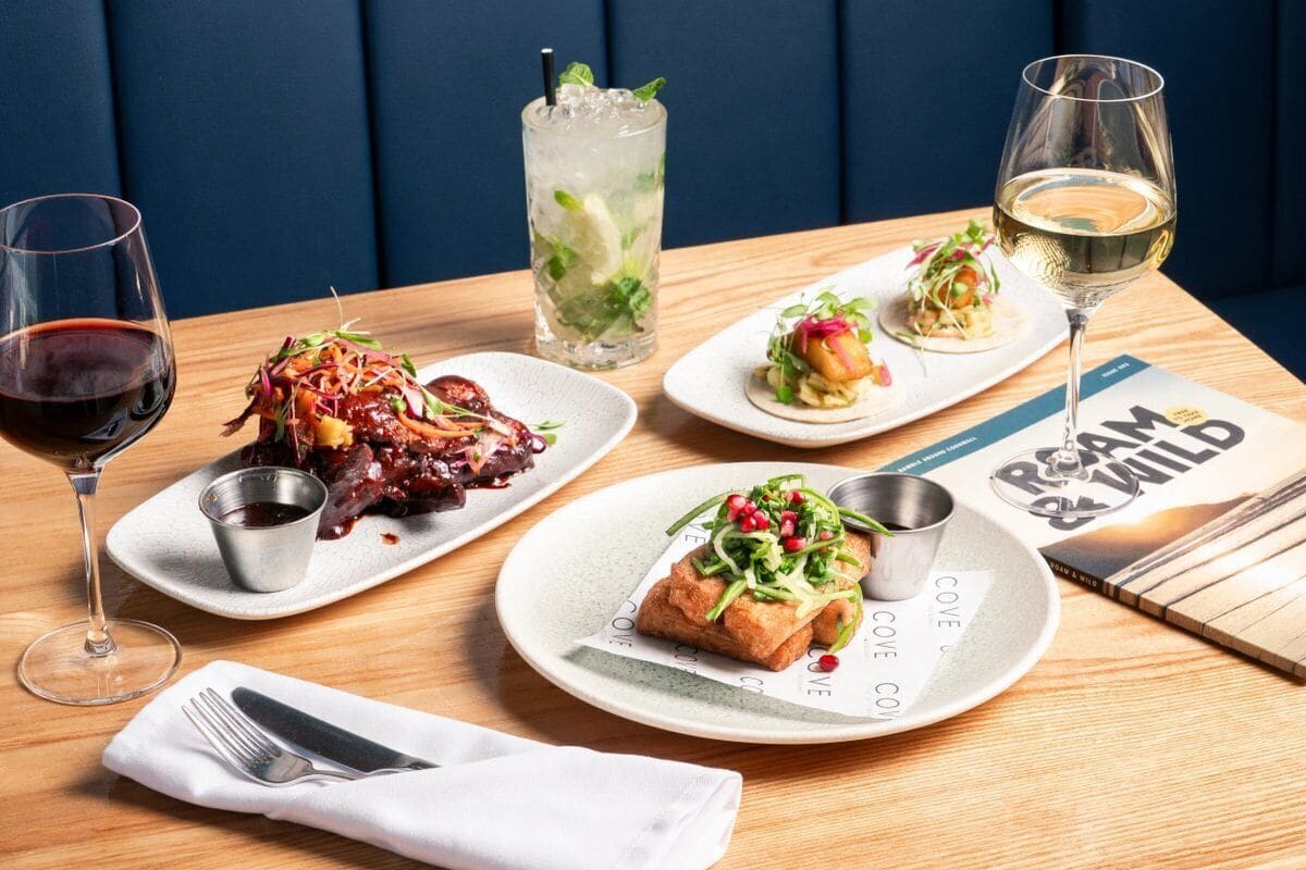 A dining table with various dishes, drinks, and a menu.