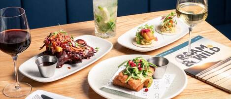 A dining table with various dishes, drinks, and a menu.