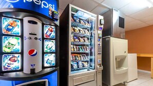 Una máquina expendedora con el logotipo de Pepsi, un dispensador de bebidas y una vitrina refrigerada para snacks.