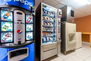 Una máquina expendedora con el logotipo de Pepsi, un dispensador de bebidas y una vitrina refrigerada para snacks.