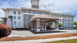 A multi-story hotel with a covered entrance, a prominent 'Ganner' sign, and a parking lot.
