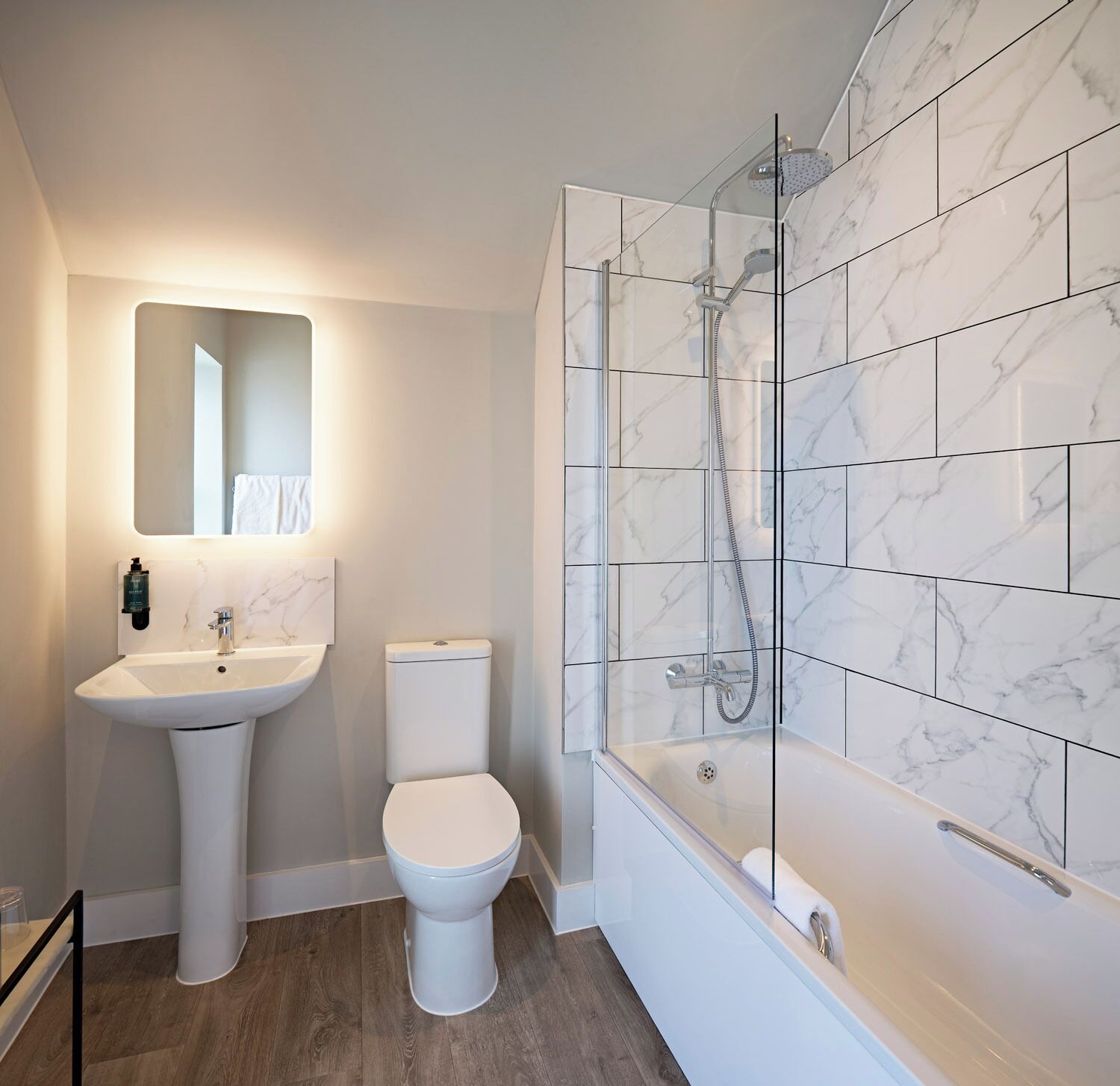 A modern bathroom with a freestanding sink, toilet, and a walk-in shower with a glass enclosure.