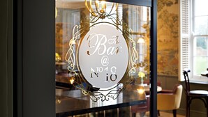 A glass door with a decorative sign reading "Bar @ No 18".