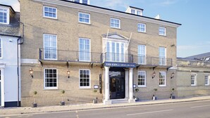 A two-story building with a sign reading 'The King's Arms Hotel.'