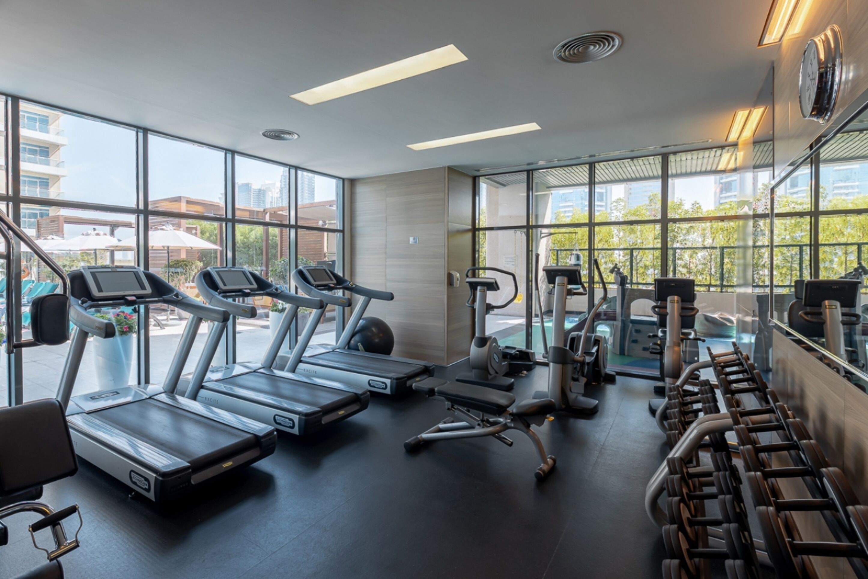 A modern gym with treadmills, exercise bikes, and weight machines.