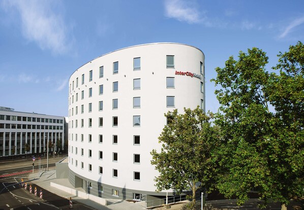 Et moderne InterCity Hotel med en buet facade, flere etager og en central indgang.