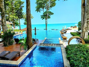 A pool area with lounge chairs, a view of the sea, and a clear sky. - Chang Buri Resort & Koh Chang Hillside (Ko Chang)