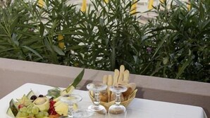 A table set for dining with a view of the sea, a fruit platter, bread basket, and wine glasses. - TH Costa Rei - Free Beach Club (Muravera)