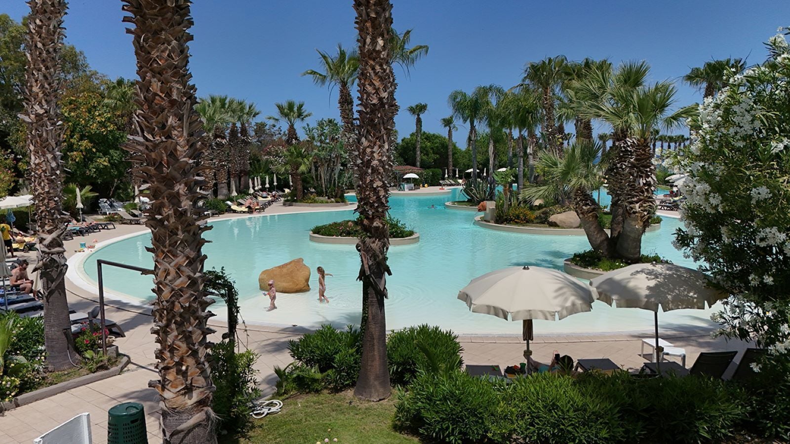 Alberca al aire libre, sombrillas en la alberca y camastros 