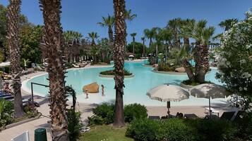 Alberca al aire libre, sombrillas en la alberca y camastros