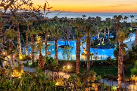 Una piscina al aire libre, sombrillas, sillones reclinables de piscina. Acacia Resort