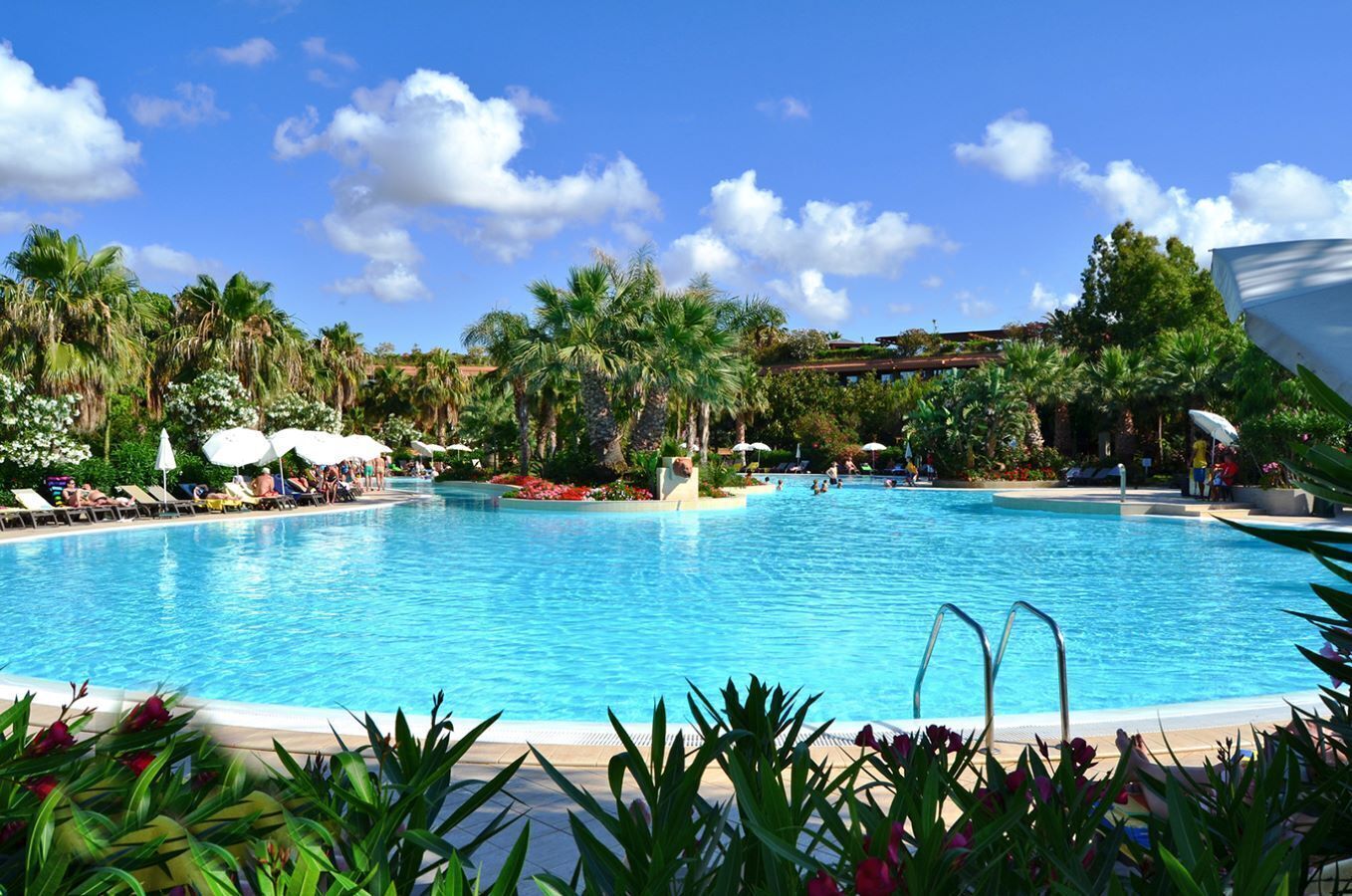 Alberca al aire libre, sombrillas en la alberca y camastros 