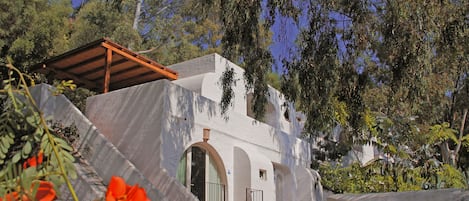 A white building with arched windows and a covered walkway.