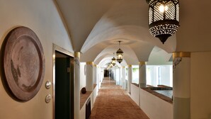 A corridor with arched ceilings, patterned floor tiles, and decorative lanterns. - Arbatax Park Resort - Telis by Falkensteiner (Tortoli)