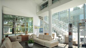 A spacious lobby with a large seating area, a staircase, and a reception desk. - Magna Grecia Village (METAPONTO)