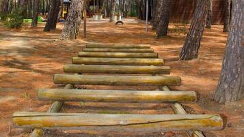 Eine Holztreppe führt in einen bewaldeten Bereich.
